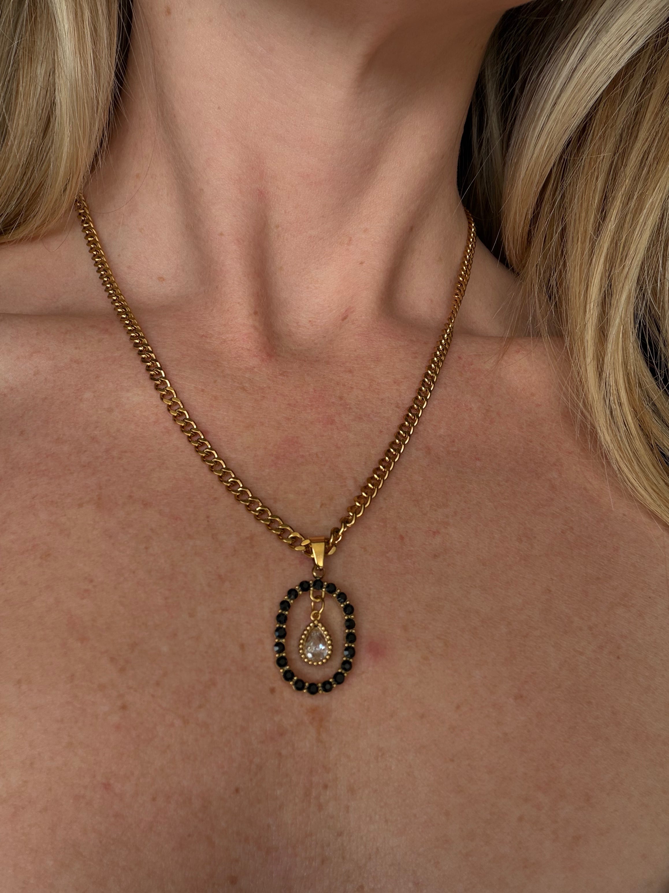 Nesta's Oath Necklace - gold curb chain with black stone oval pendant and crystal teardrop charm